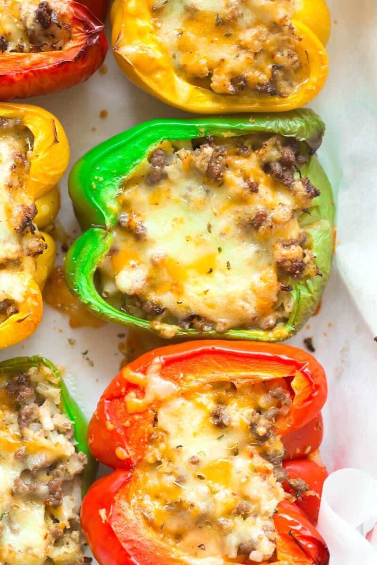 stuffed gree, yellow and red peppers on a sheet