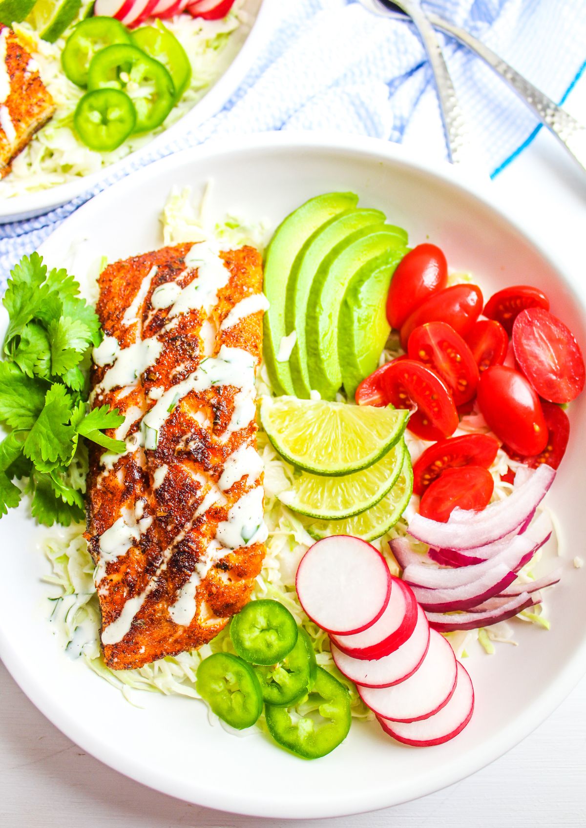 a plate of fish fillet, sliced pear, tomoateos, sliced jalapenos, sliced radish and lime