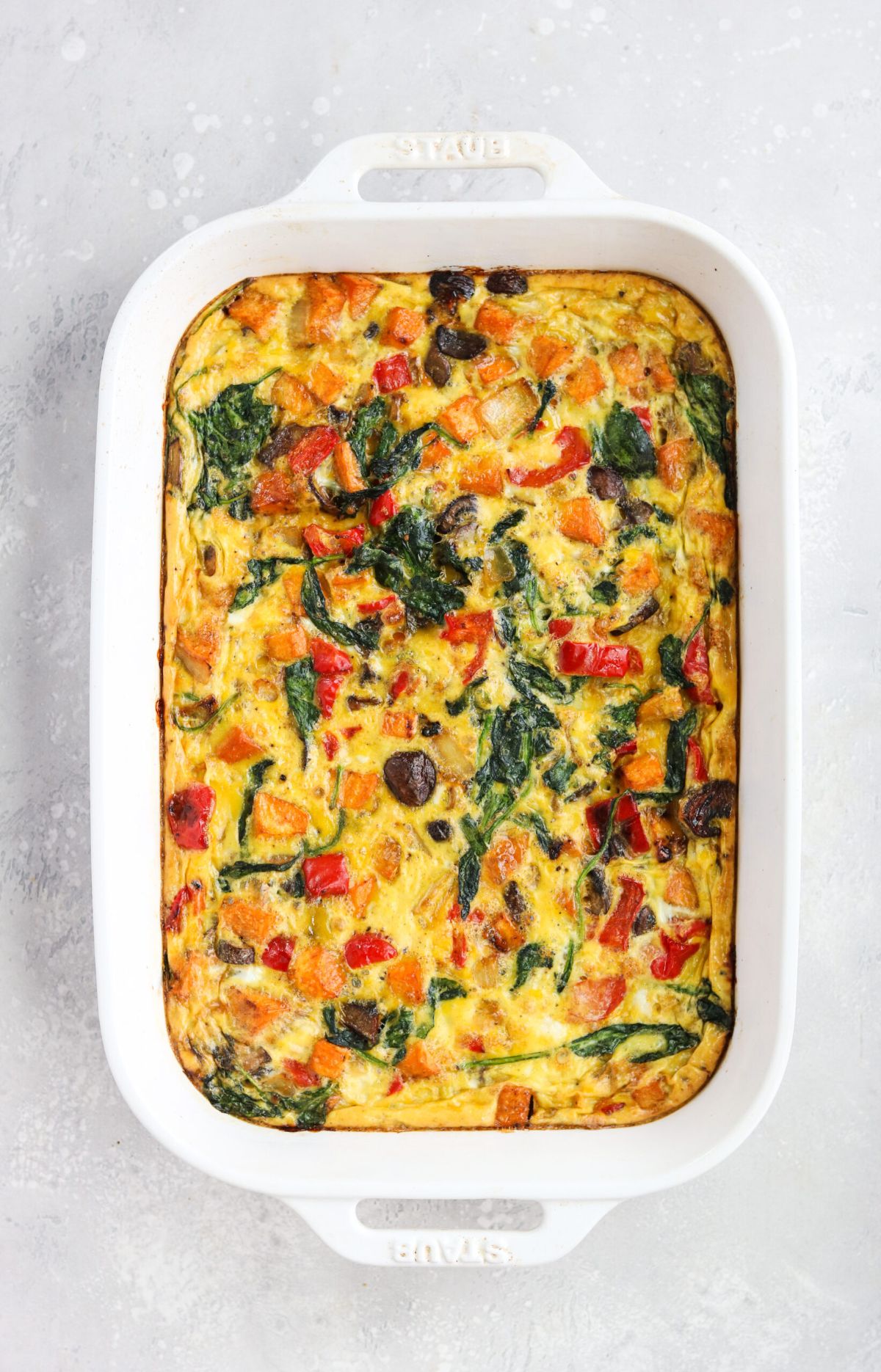 a white rectangular oven dish with a vegetable casserole in it