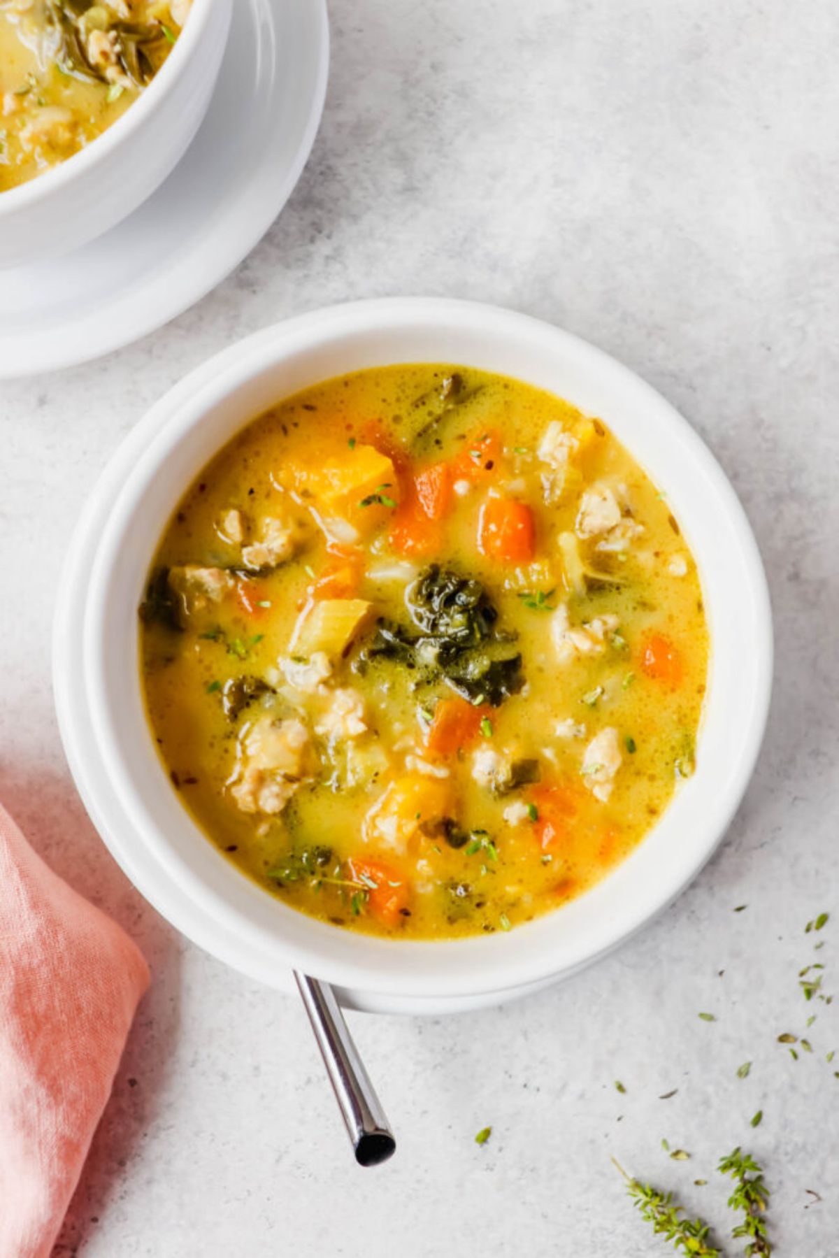 A white bowl of turkey and kale soup