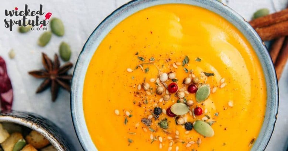 a bowl of sweet potatoe soup garnished with seeds.