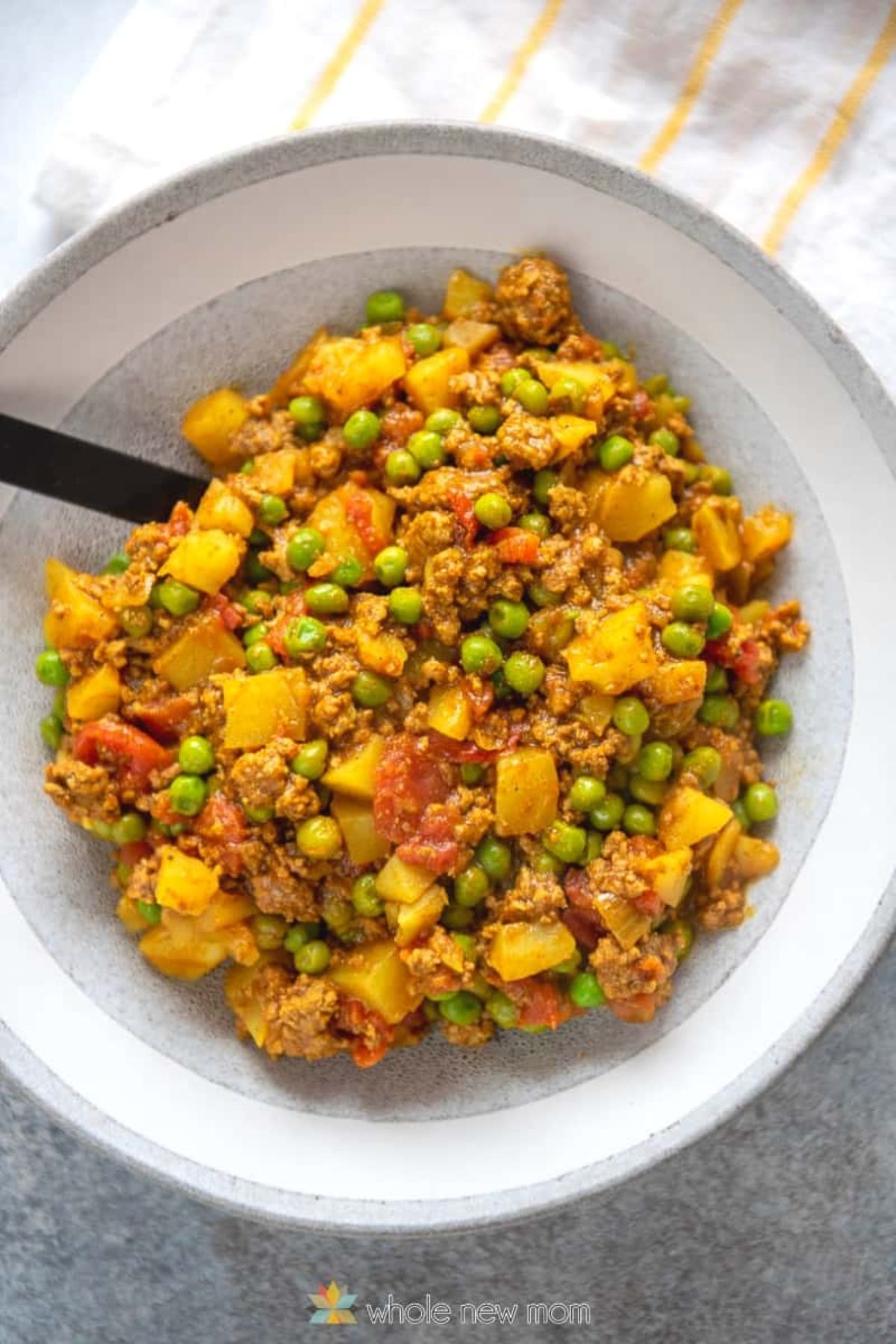 A whote bowl of curried ground beef and vegetables