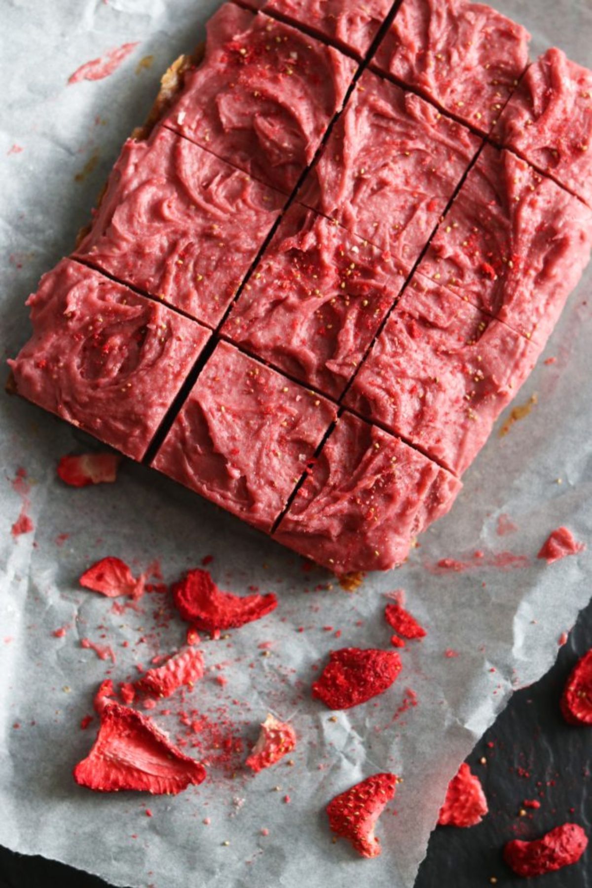 a tray bake of strawberry cheesecake bars, cut into pieces