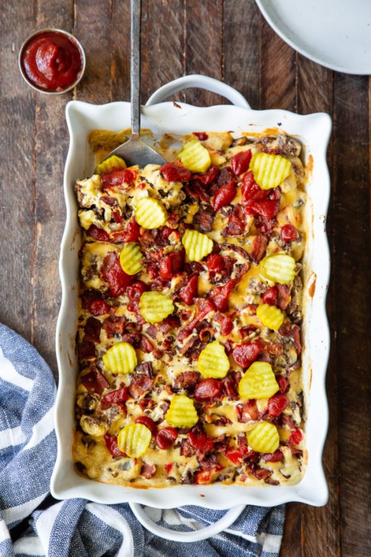 a rectangular white oven dish with a cheeseburger casserole inside, topped with potato chips