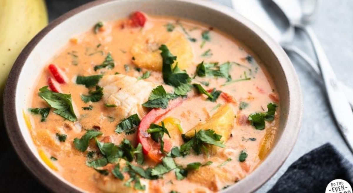 an oval casserole dish with brazilian fish stew inside, sprinkled with parsley