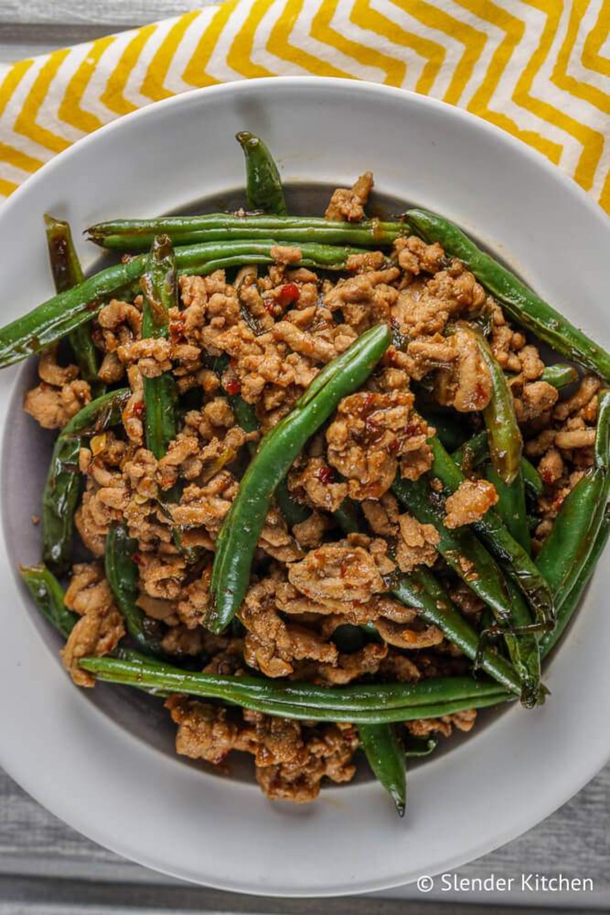 A white plate of ground turkey and green beans