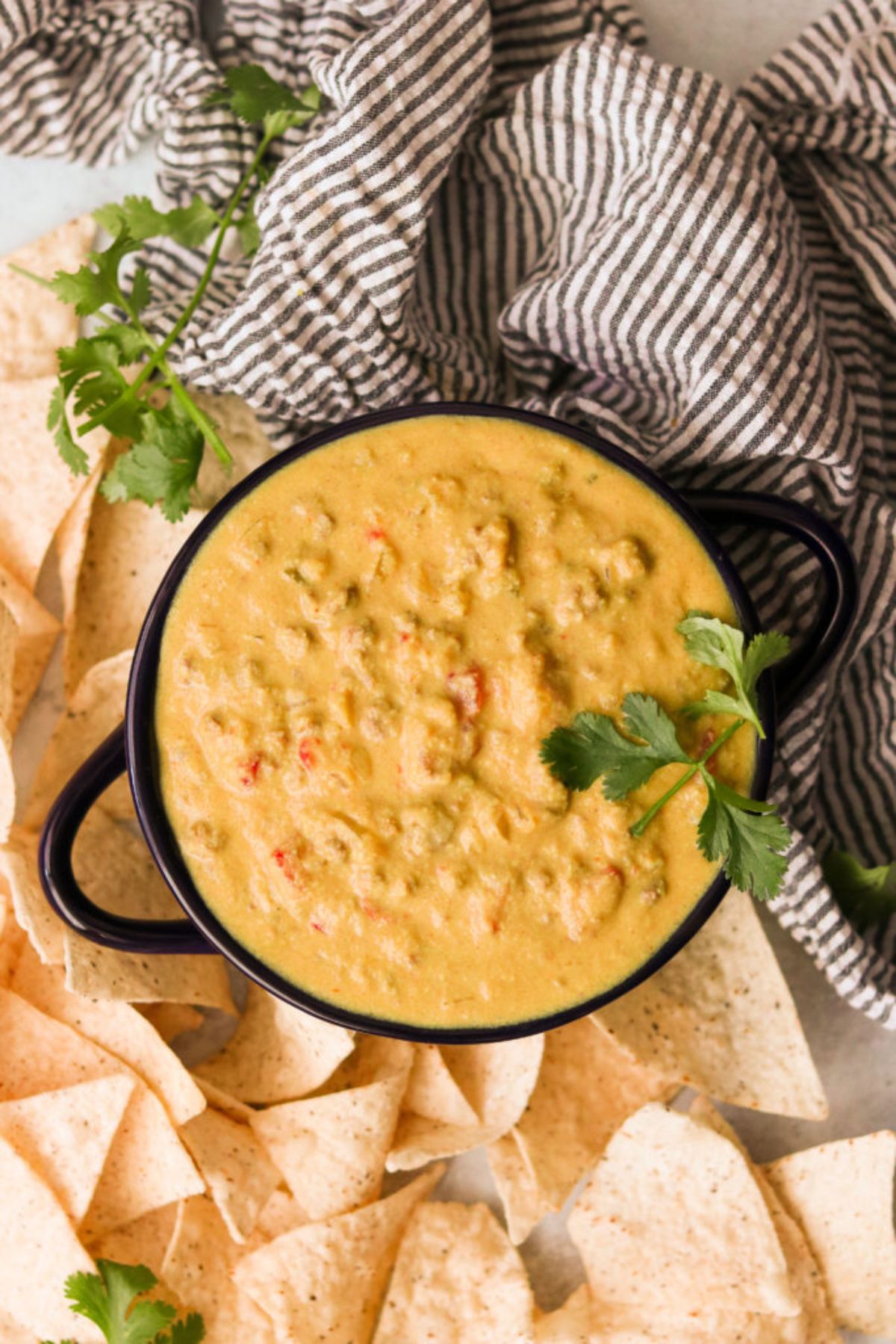 A cast iron round skillet filled with creamy orange mixture, and topped with cilantro leaves