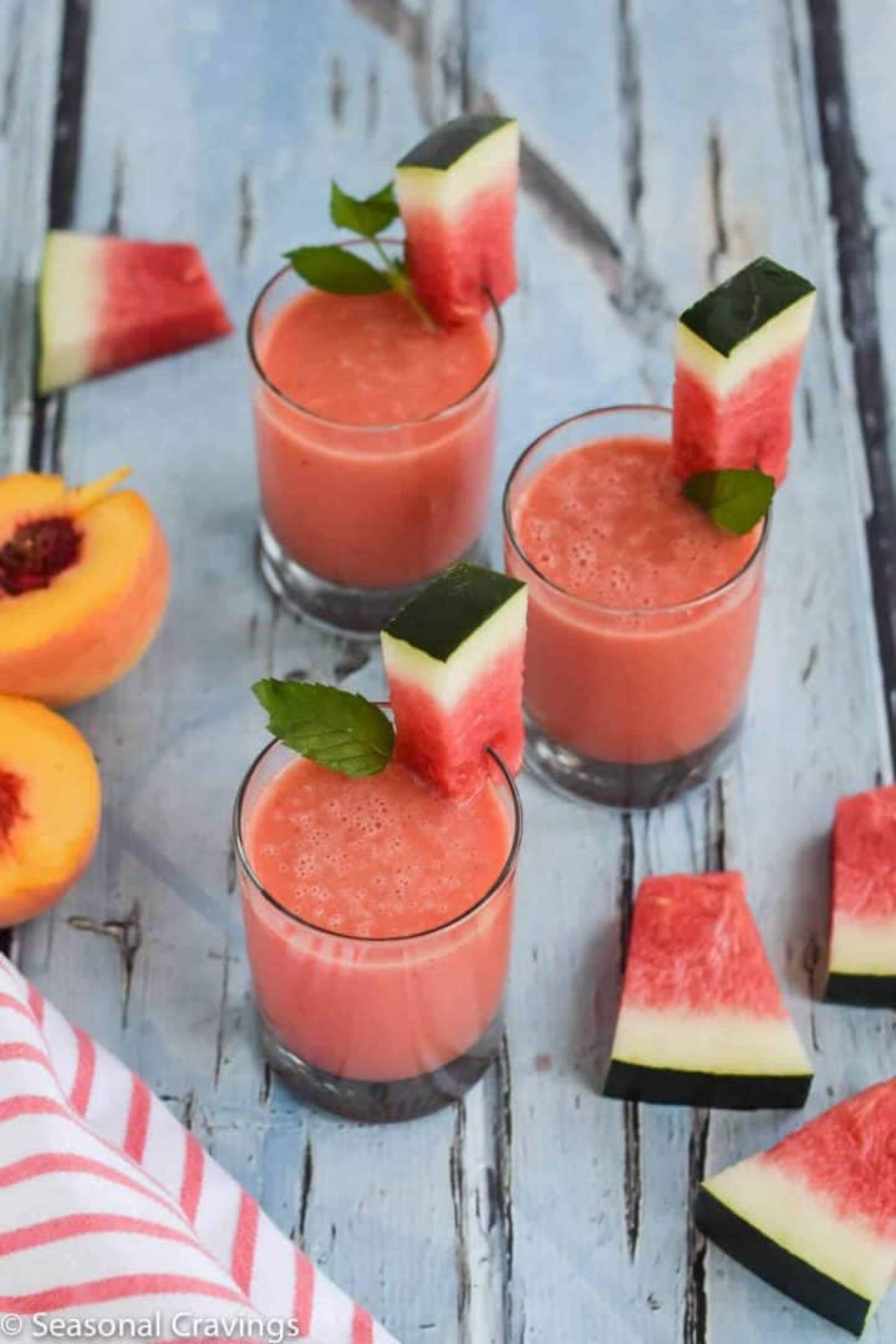 3 glasses of watermelon peach smoothie garnished with watermelon chunks and fresh mint