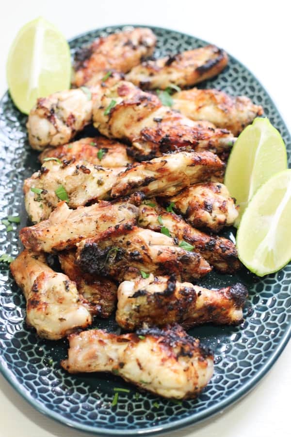 grilled cilantro lime chicken wings on a plate with lime wedges