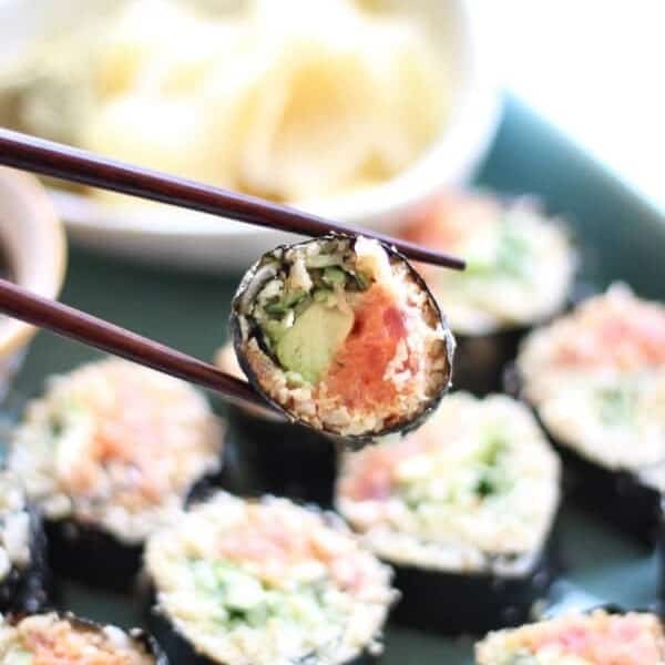 Paleo Cauliflower Rice Sushi Rolls Recipe (Spicy Tuna) - Sushi roll with chop sticks