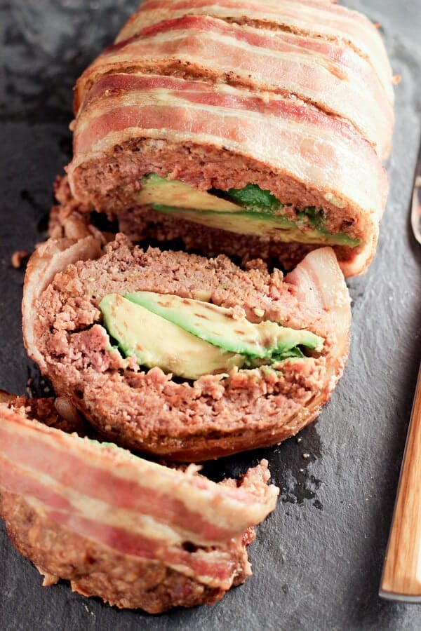 Overhead Shot Of Sliced Avocado Stuffed Mexican Meatloaf On Black Platter