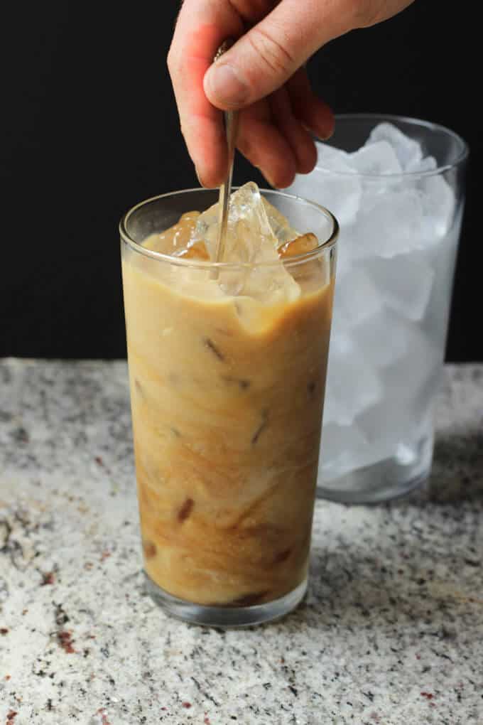 Hand stirring coffee with spoon