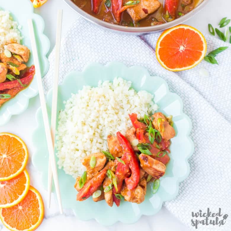 two plates of paleo orange chicken and cauliflower rice