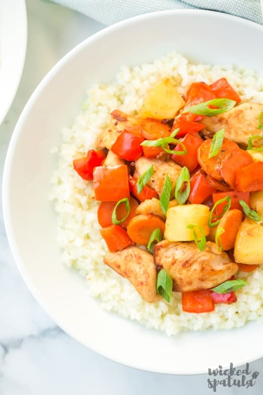 white bowl of pineapple chicken stir fry recipe over cauliflower rice