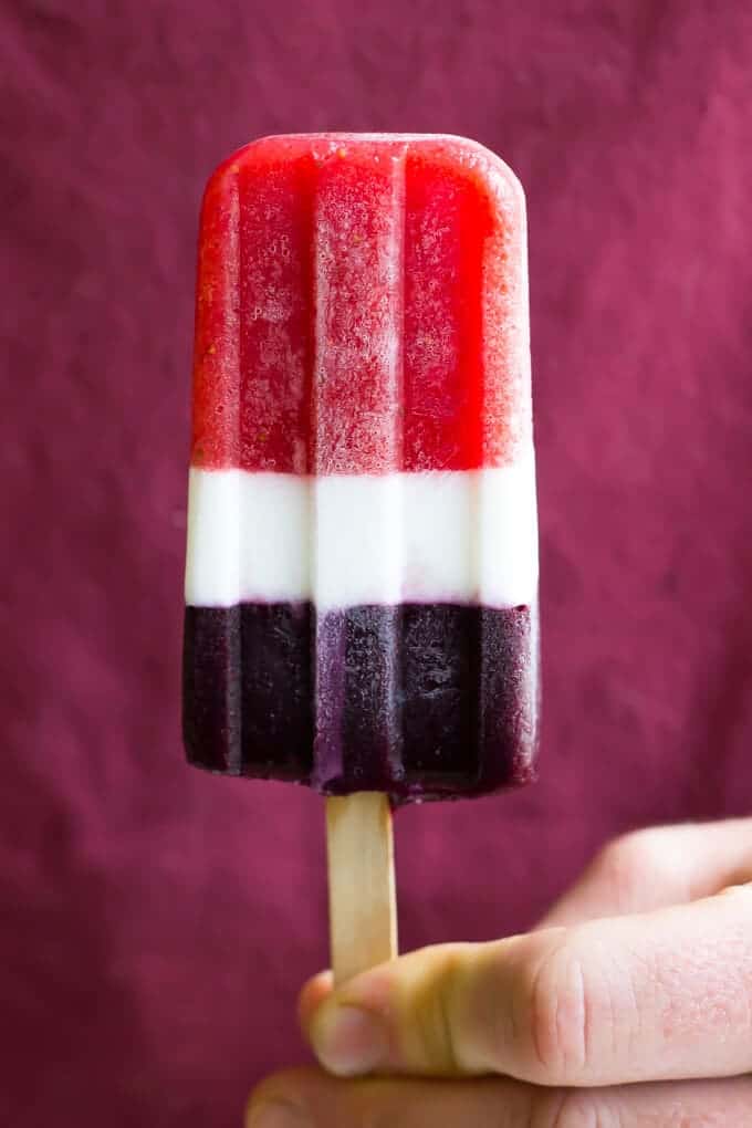 hand holding red, white and blue popsicles
