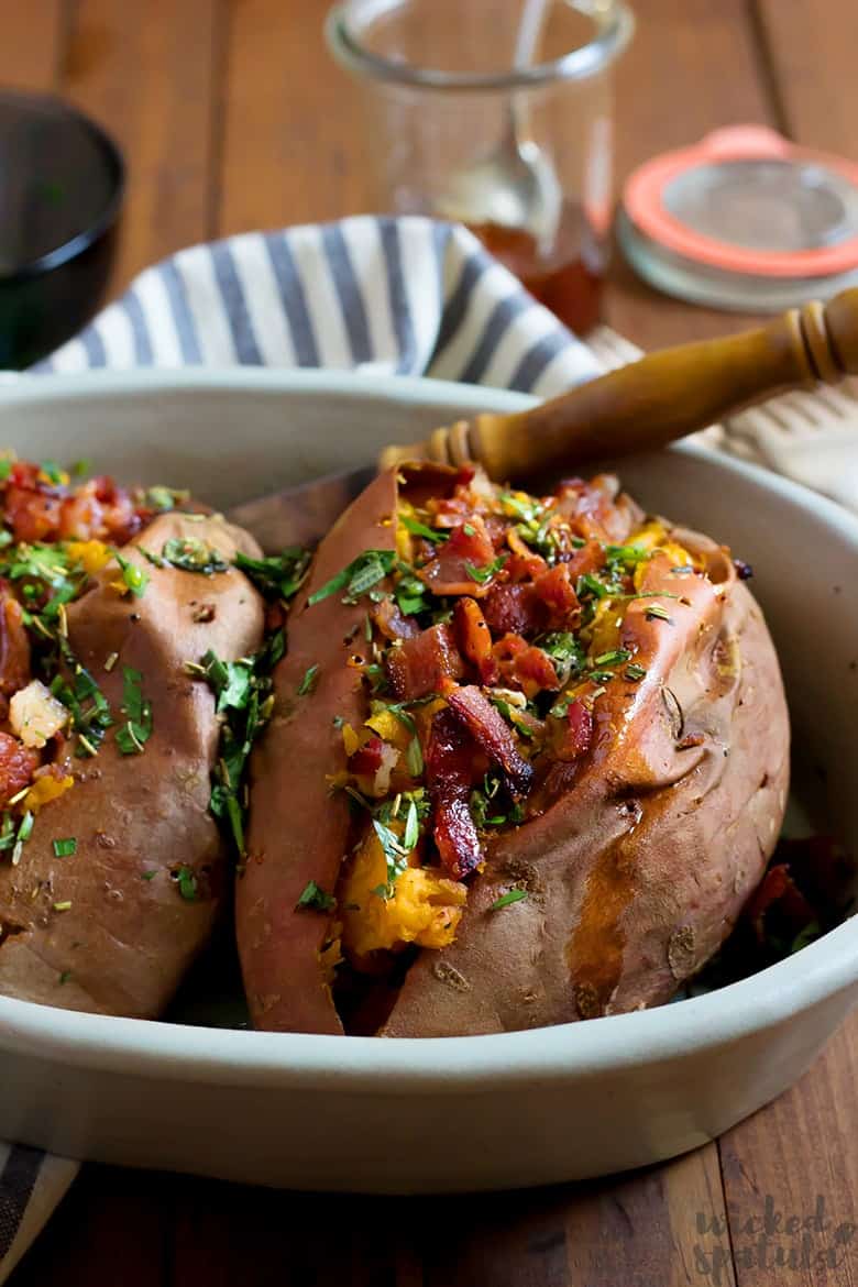 best baked sweet potatoes in baking dish with fresh herbs