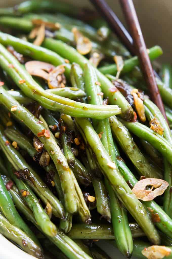 Close up image of spicy asian green beans in bowl with chopsticks