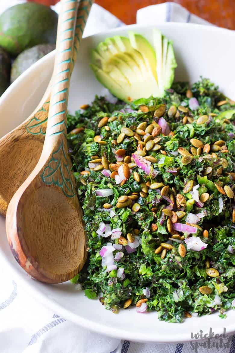 vegan kale Caesar salad in a bowl with wooden salad spoons