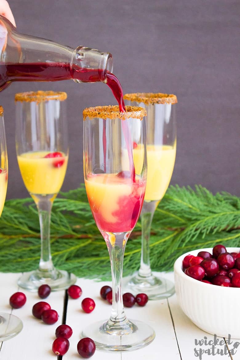 cranberry juice being poured into cranberry orange mimosa