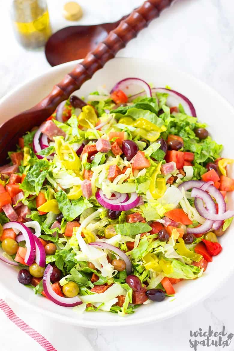 Italian green salad in bowl with spoon