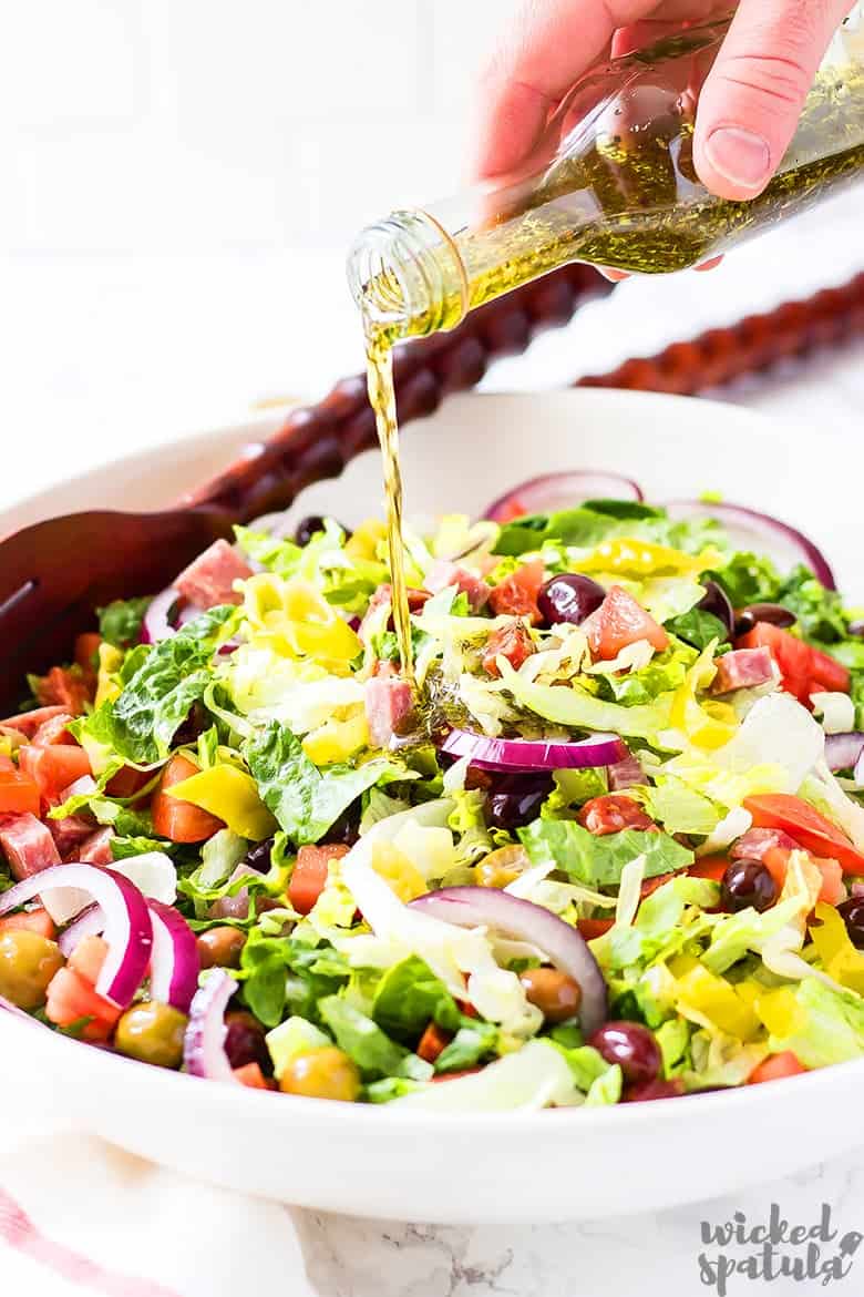 Italian salad with dressing being drizzled