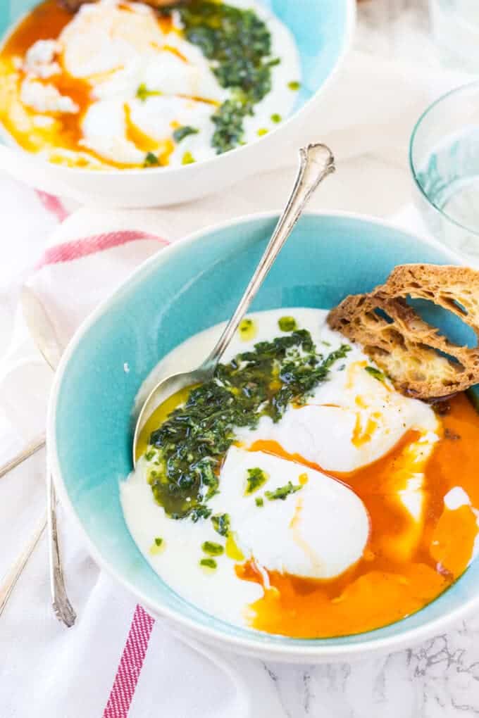 Turkish Poached Eggs - Garlic infused yogurt gets topped with poached eggs, spiced browned butter, and a fragrant chimichurri 