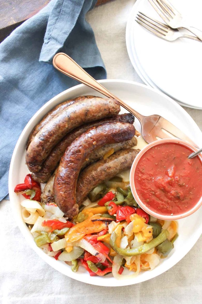 Overhead Shot Of Crock Pot Sausages Peppers And Onions With Sauce in Bowl 