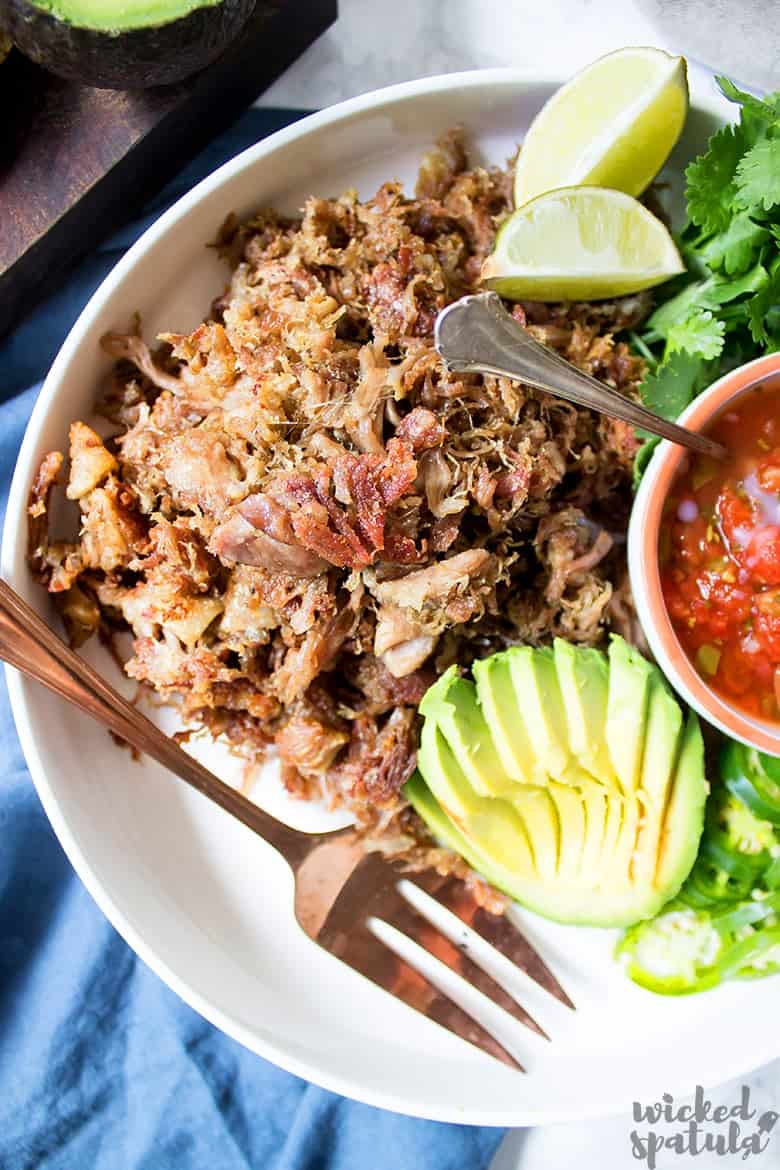 Crock Pot carnitas on a platter with toppings