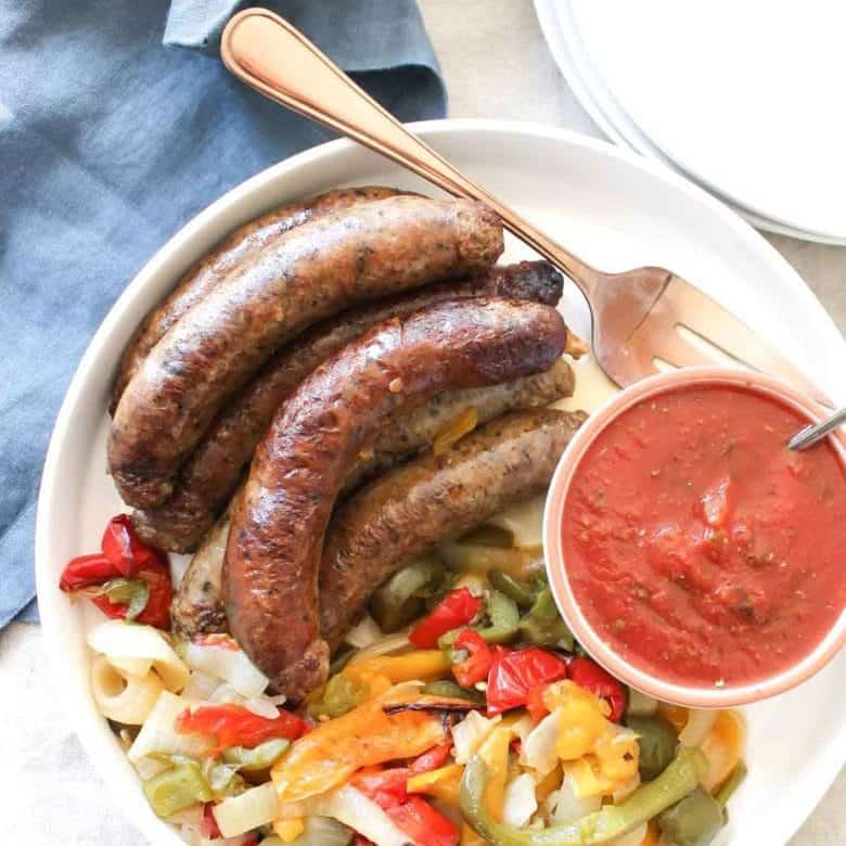 Overhead Shot Of Crockpot Sausages With Peppers And Onions On Plate