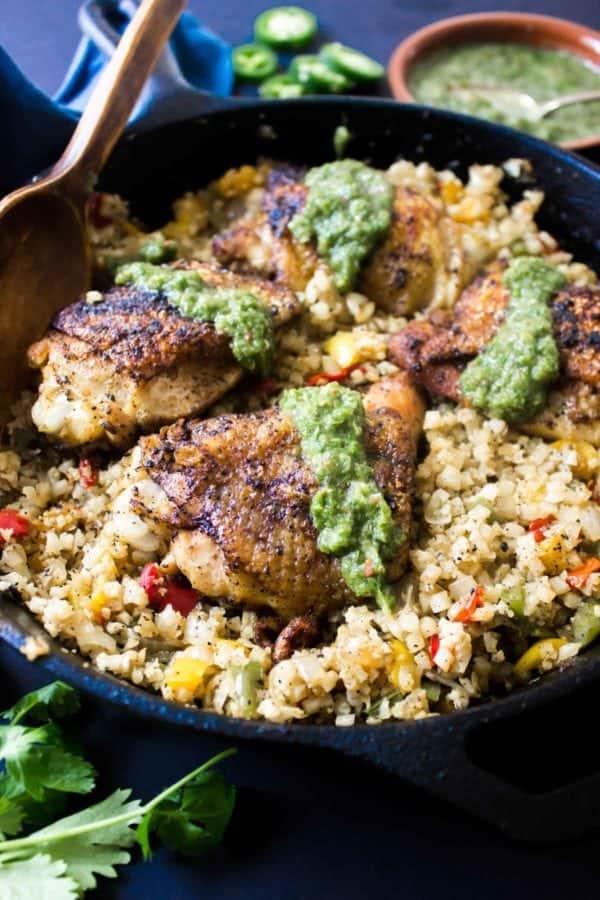 This flavorful Latin Paleo Arroz Con Pollo is packed full of delicious cauliflower rice, crispy chicken, onions, peppers, and a tangy hot sauce!