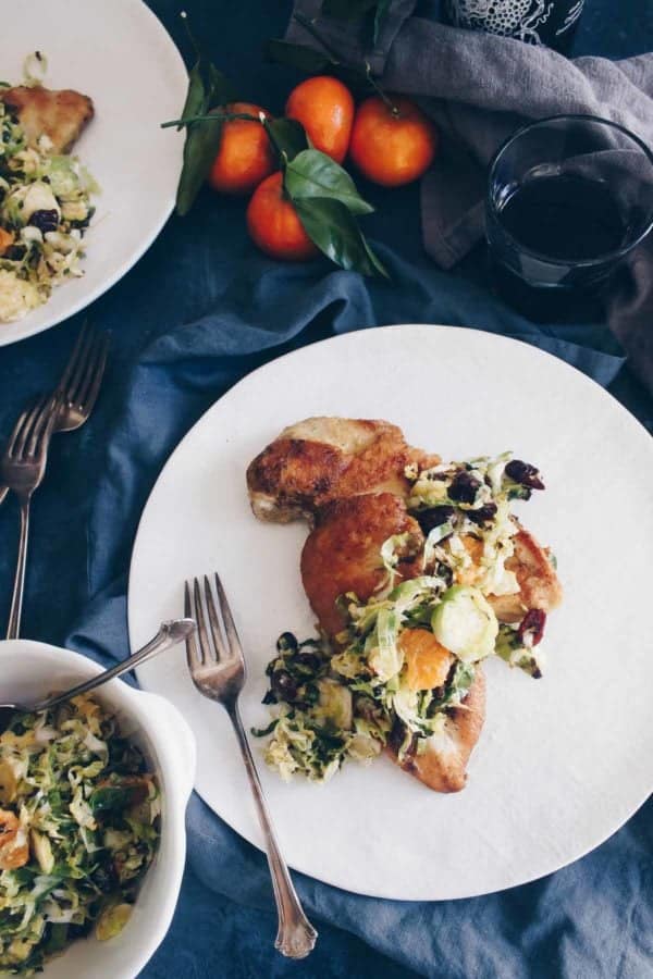 This quick 30 minute meal is just as elegant as it is nutritious. Pan seared chicken gets topped with Brussels sprouts slaw with oranges and cranberries. Paleo friendly!