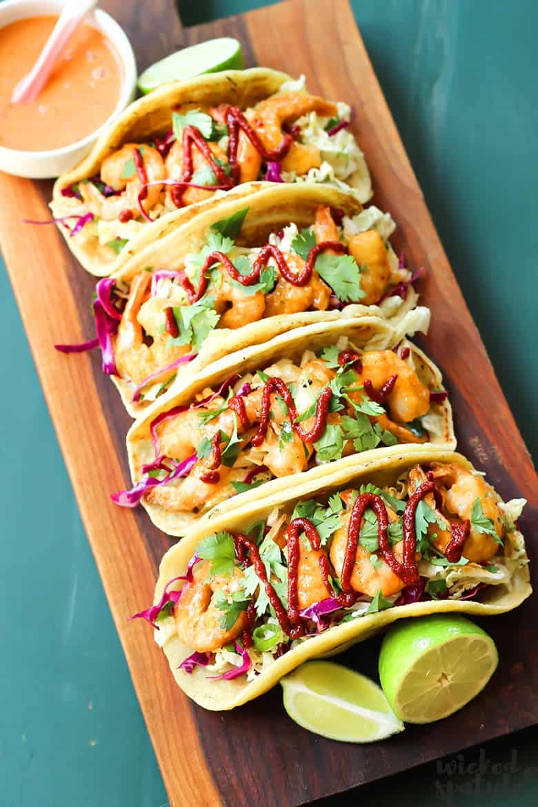 4 bang bang shrimp tacos on a platter