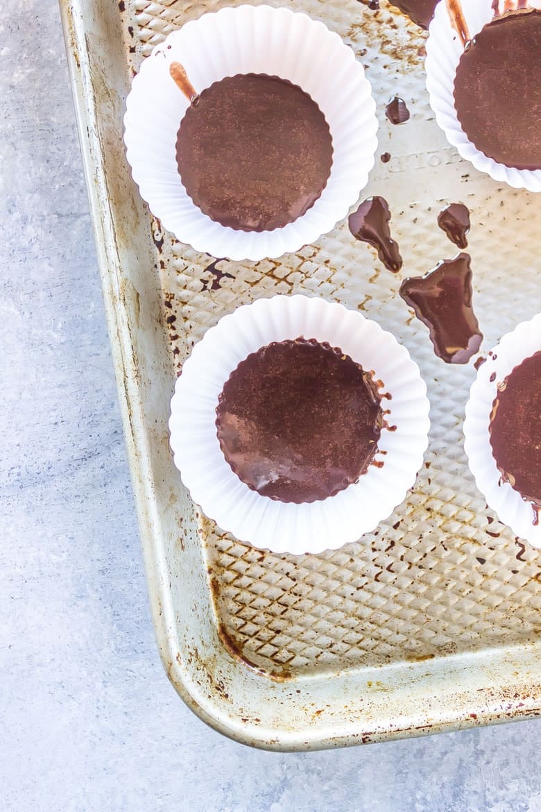 Overhead Shot Of Paleo Almond Butter Cup Mixture In Paper Cups On Baking Sheet