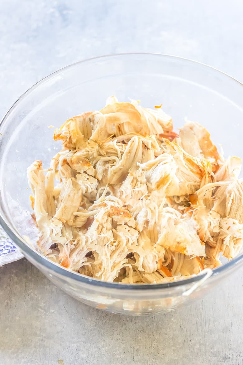 Overhead Shot Of Shredded Cooked Chicken In Glass Bowl