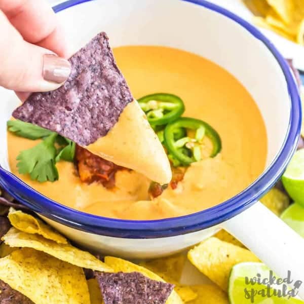 The Best Vegan Queso Recipe - Bowl with queso and dip on chip
