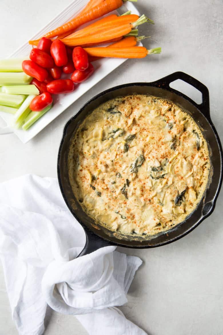 skillet with spinach artichoke dip recipe and veggies