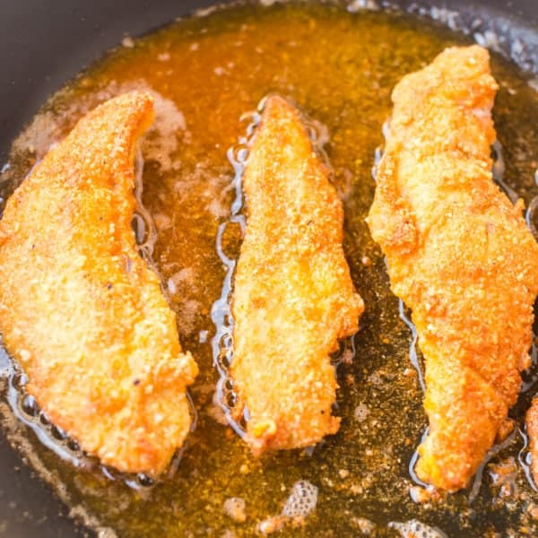 paleo chicken tenders frying in coconut oil