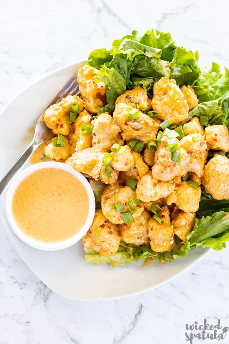 bang bang shrimp sauce recipe tossed with chicken on green lettuce