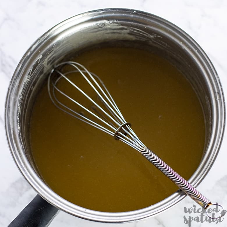 caramel being stirred in pan for dairy-free pecan pie