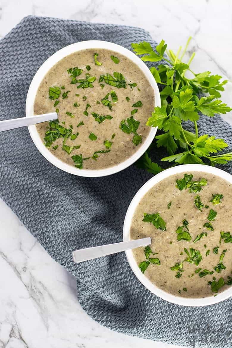 two bowls of cream of mushroom soup with two spoons