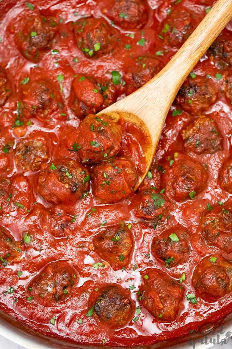 paleo Italian meatballs simmering in sauce