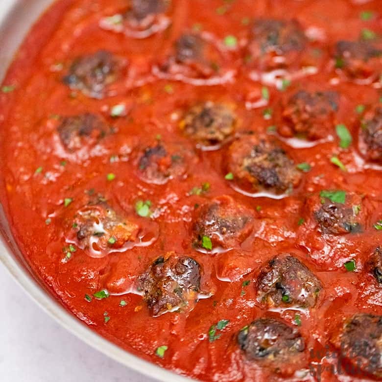 paleo meatballs simmering in tomato sauce
