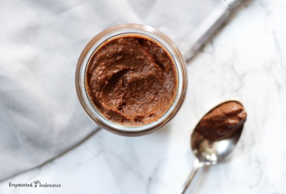 a pot of chocolate sweet potato pudding and a spoon next to it