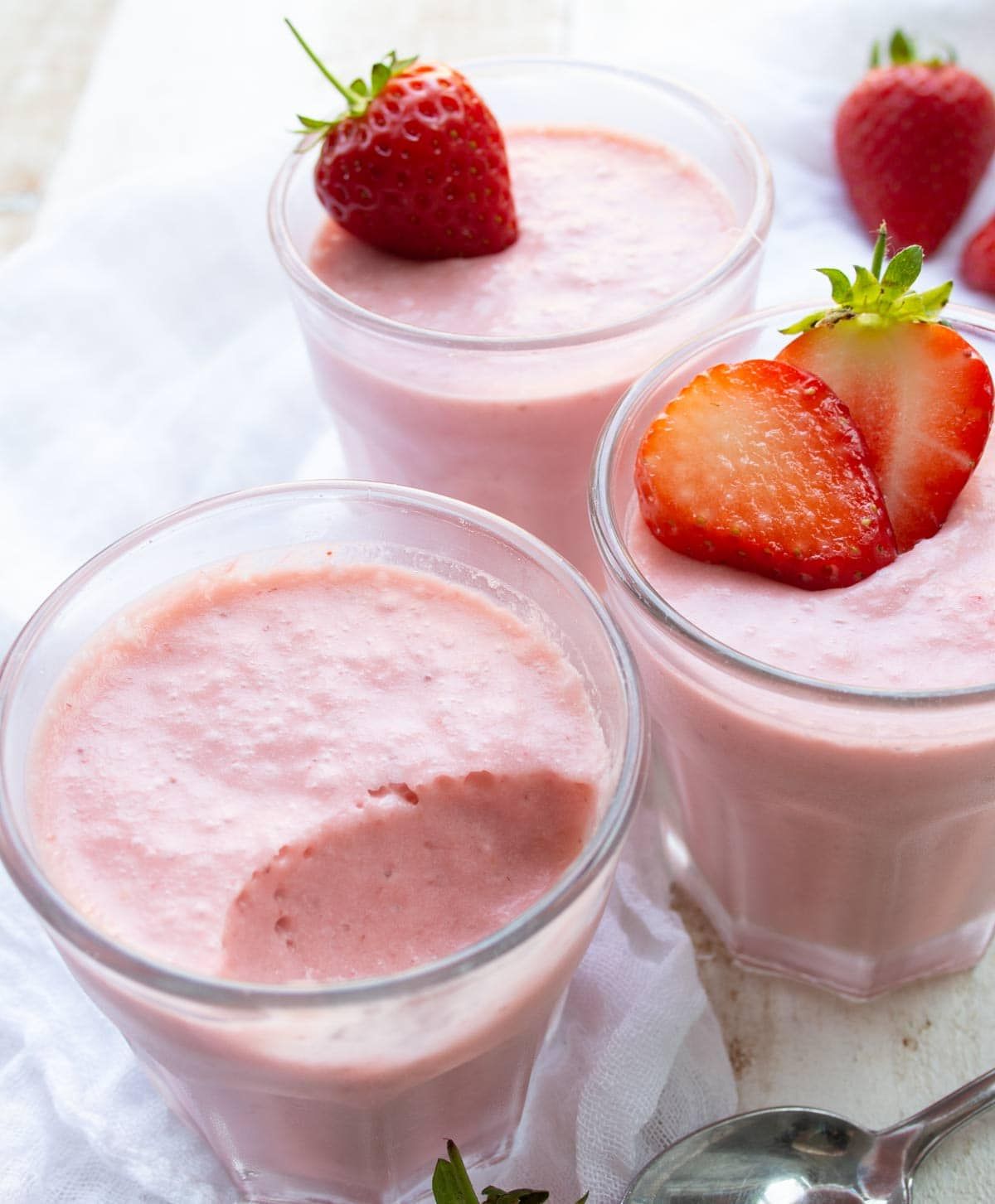 3 glasses of strawberry mousse topped with fresh strawberries