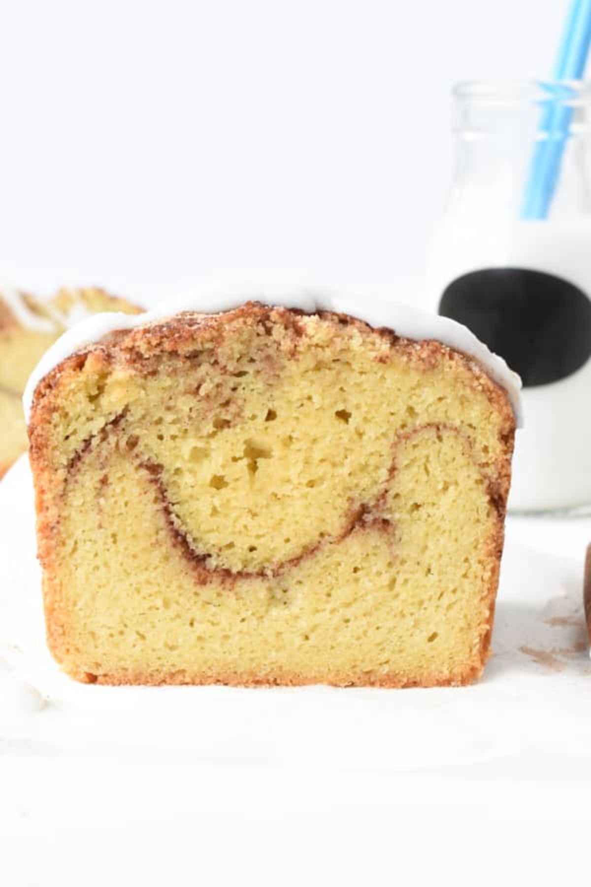 A cut away view of a loaf of cinnamon bread with white icing