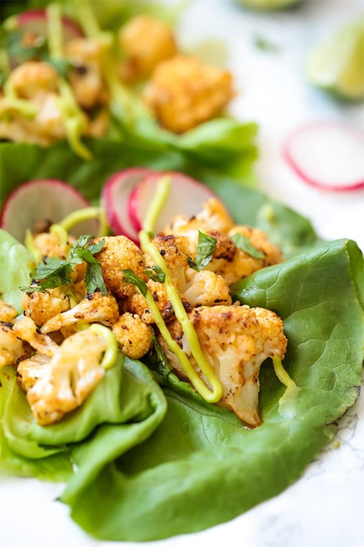 Lettuce leaves filled with bang bang cauliflower and sliced radish