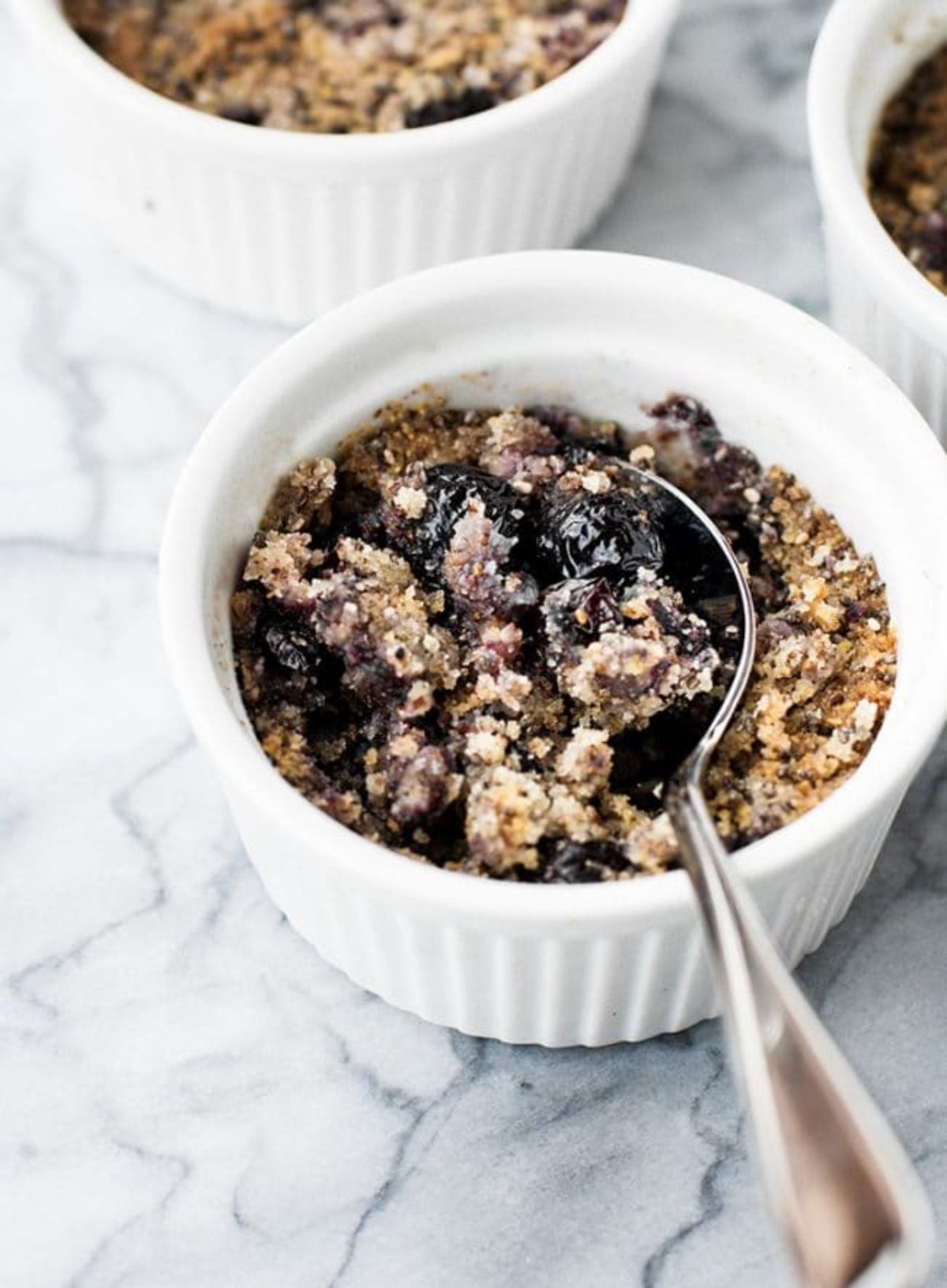 3 small white pots of blueberry crumble