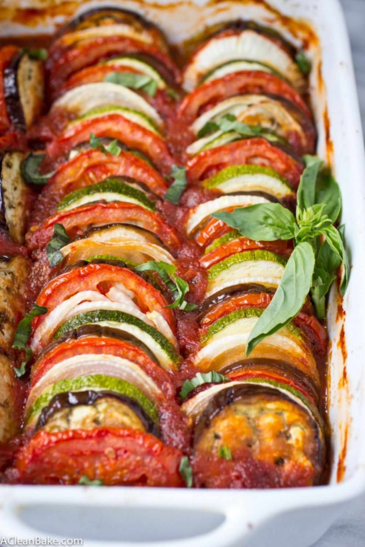 A casserole dish with slices of roasted aubergine, tomato and zucchini
