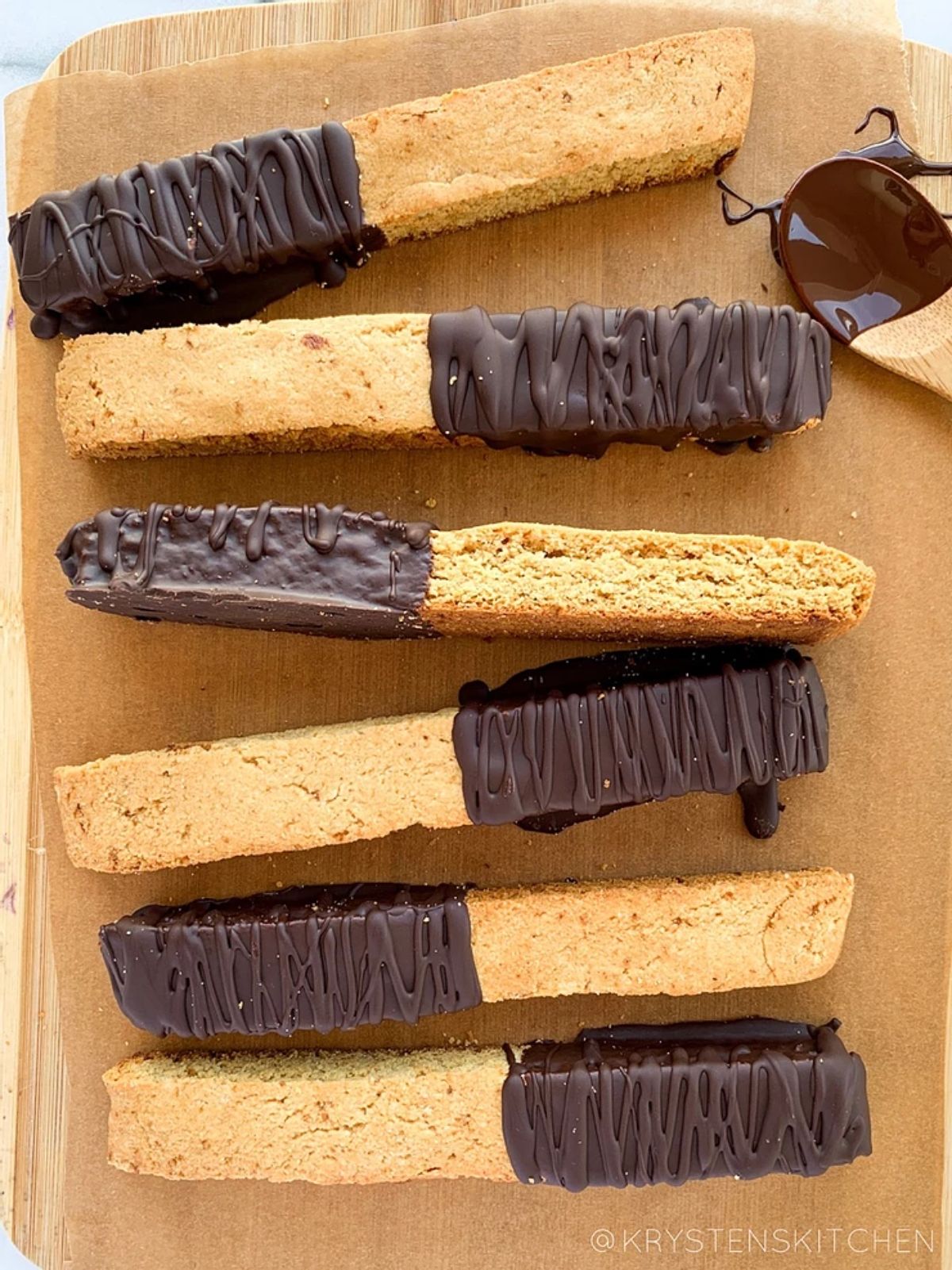 a wooden tray with 6 chocoloate-dipped almond biscotti