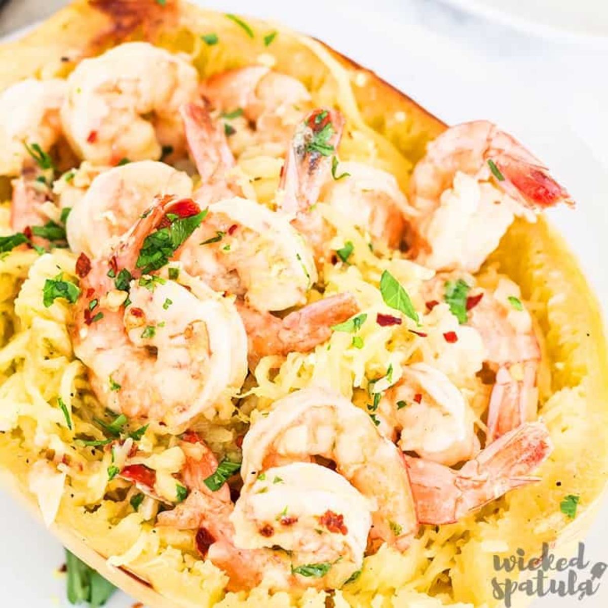a hollowed out baked spaghetti squash filled with shrimp and herbs